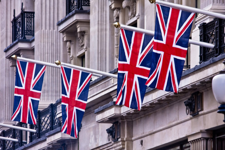 great britain flags hanging outside a stately building