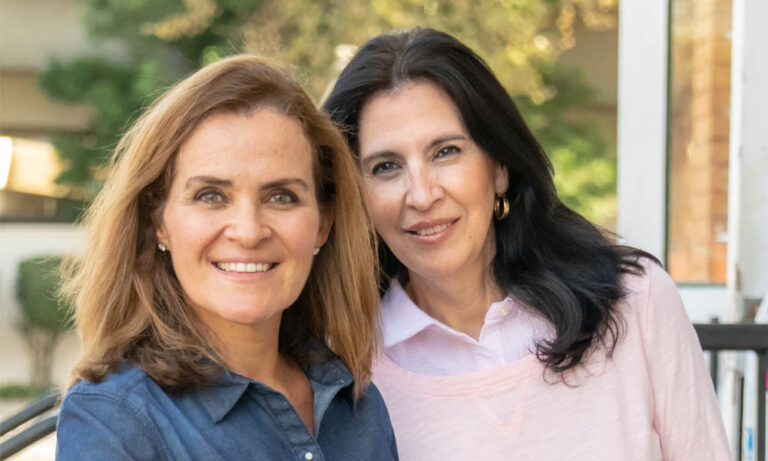 Two adult women, smiling at camera