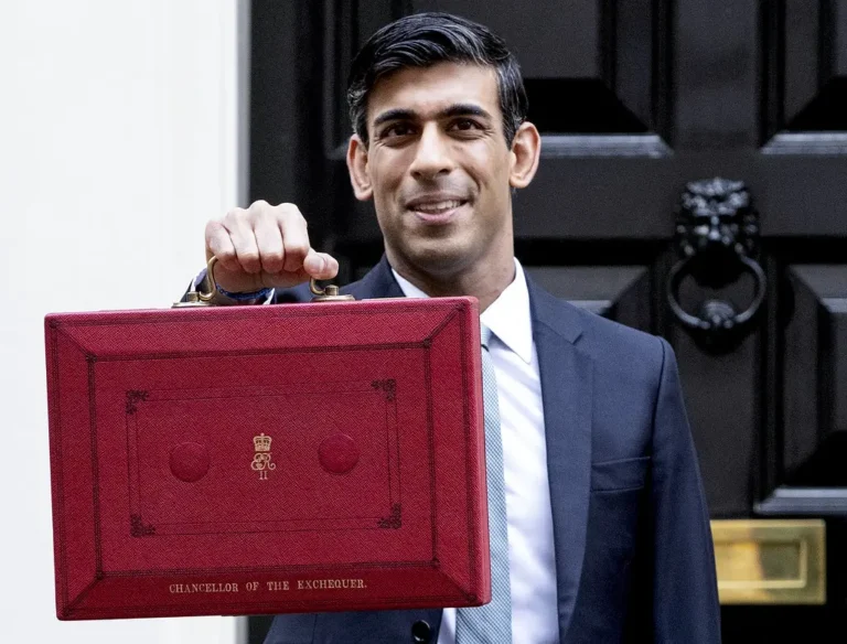 UK Chancellor holding up a red briefcase